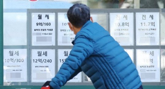 한 시민이 부동산공인중개업소 매물정보 게시판에 붙은 시세를 확인하고 있다. <연합뉴스>